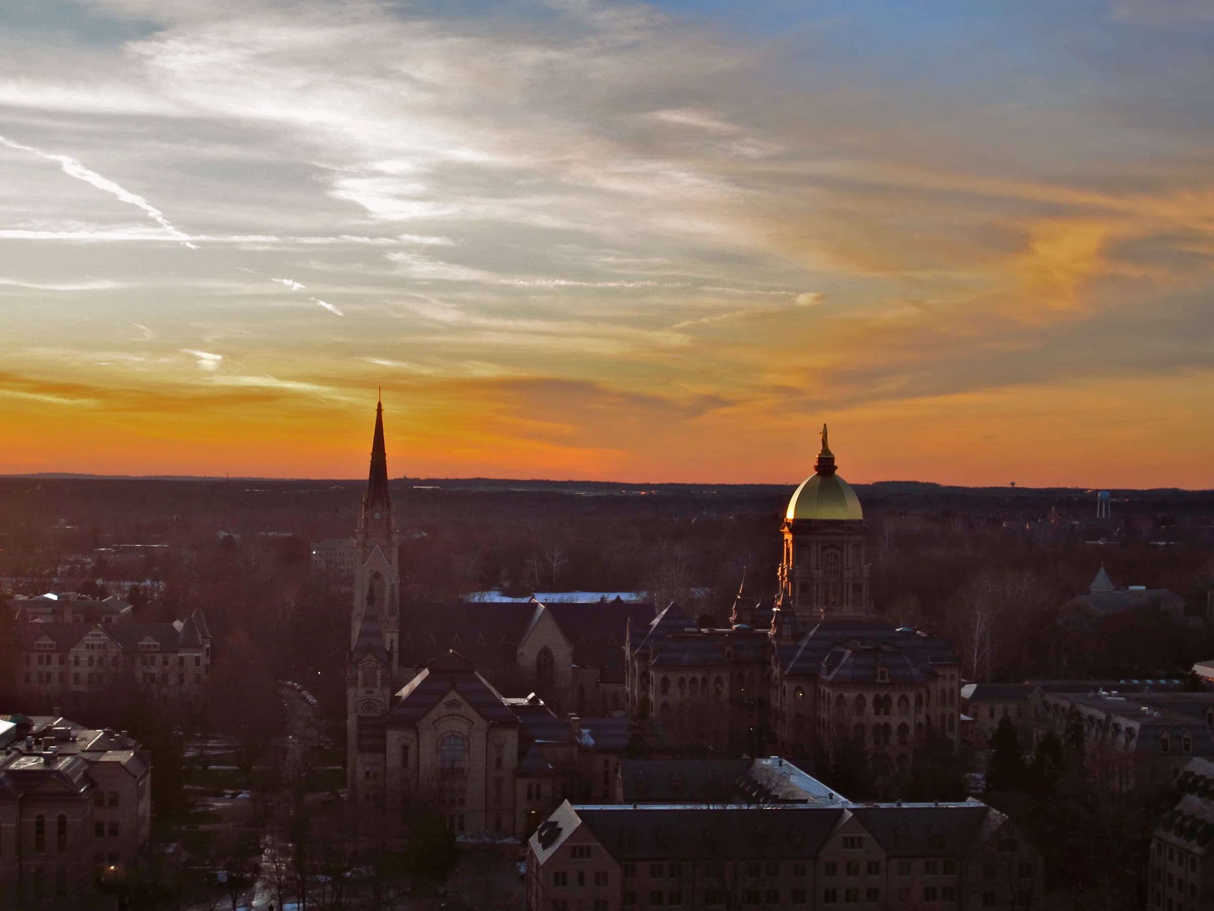 Notre Dame's Golden Dome and basilica beneath a golden sky, photographed from Father Ted Hesburgh's office in January 2012